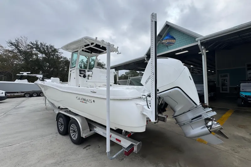 Slide: The Image of 2026 Caymas 281 HB boat on trailer, parked outdoors near a building. - 16