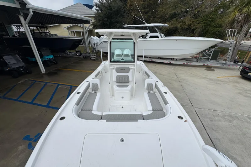 Slide: The Image of 2026 Caymas 281 HB boat with spacious seating, parked in a marina. - 24