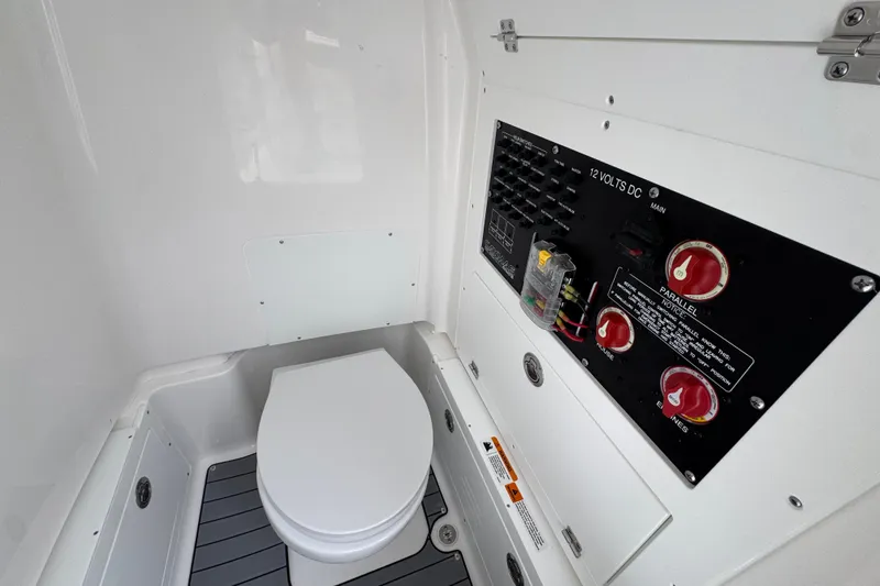 Slide: The Image of Interior of 2026 Caymas 281 HB boat featuring a compact marine toilet and control panel. - 28