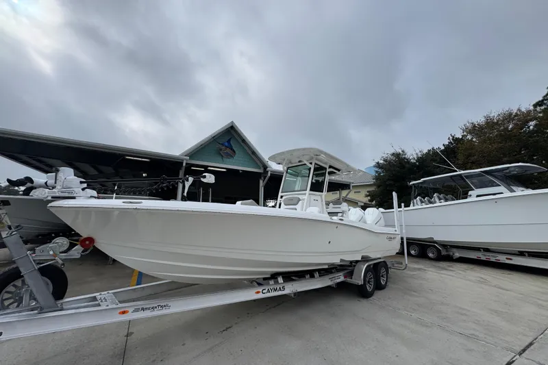 Slide: The Image of 2026 Caymas 281 HB boat on trailer, parked outdoors under cloudy sky. - 3