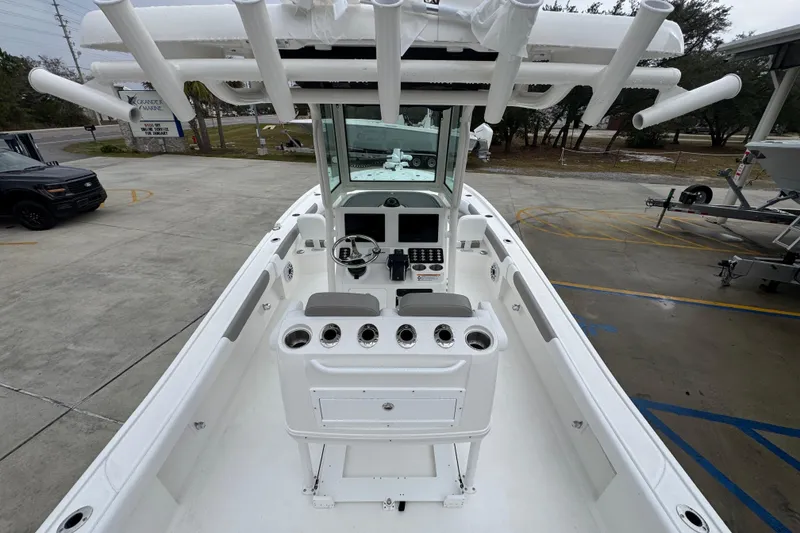 Slide: The Image of 2026 Caymas 281 HB boat interior with helm, rod holders, and seating in a marina setting. - 38