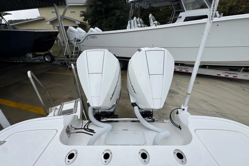 Slide: The Image of 2026 Caymas 281 HB boat with dual Mercury outboard engines at a marina. - 39