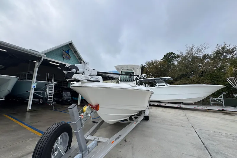 Slide: The Image of 2026 Caymas 281 HB boat on trailer at dealership, overcast sky. - 5