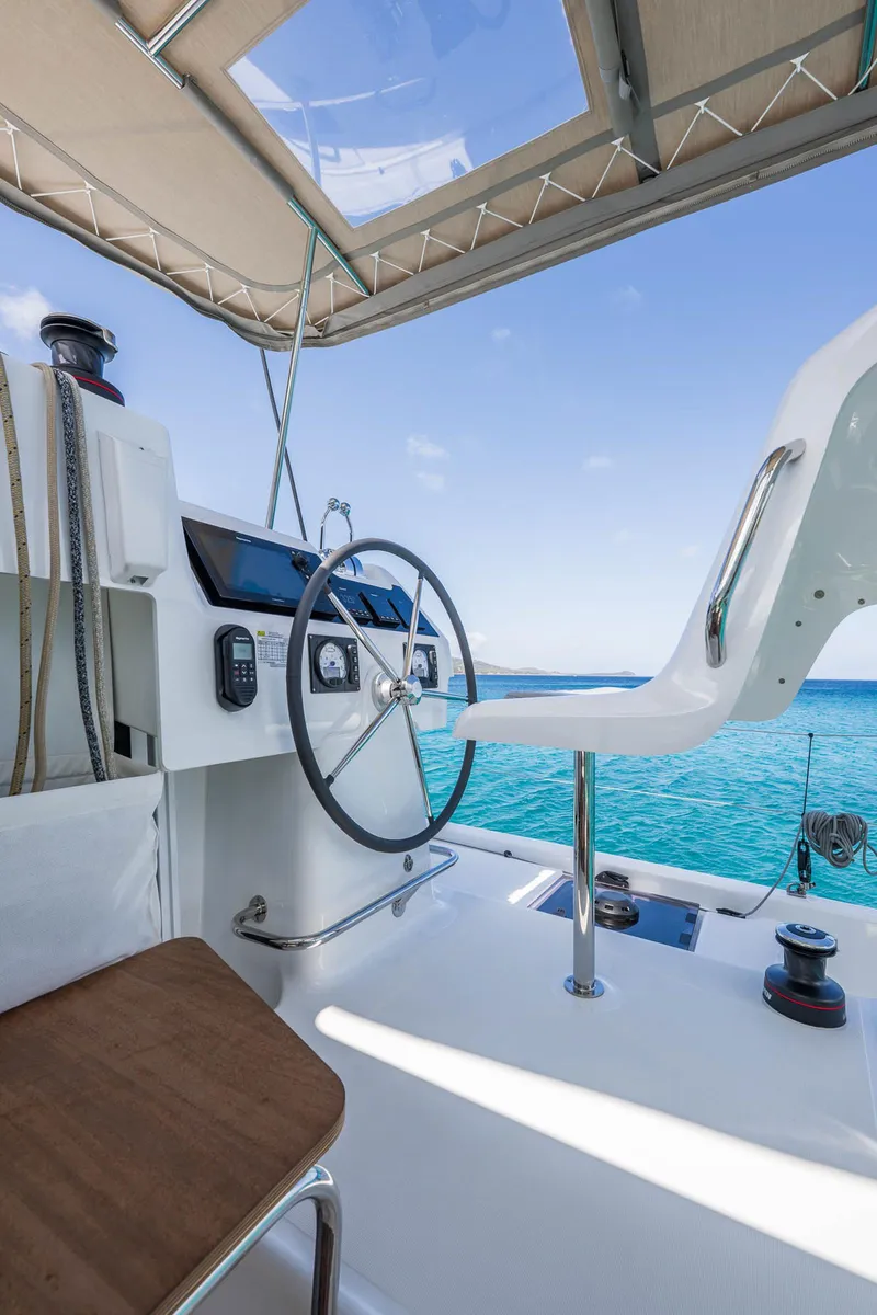 Slide: The Image of Helm of 2025 Lagoon 38 catamaran with ocean view and modern controls. - 13