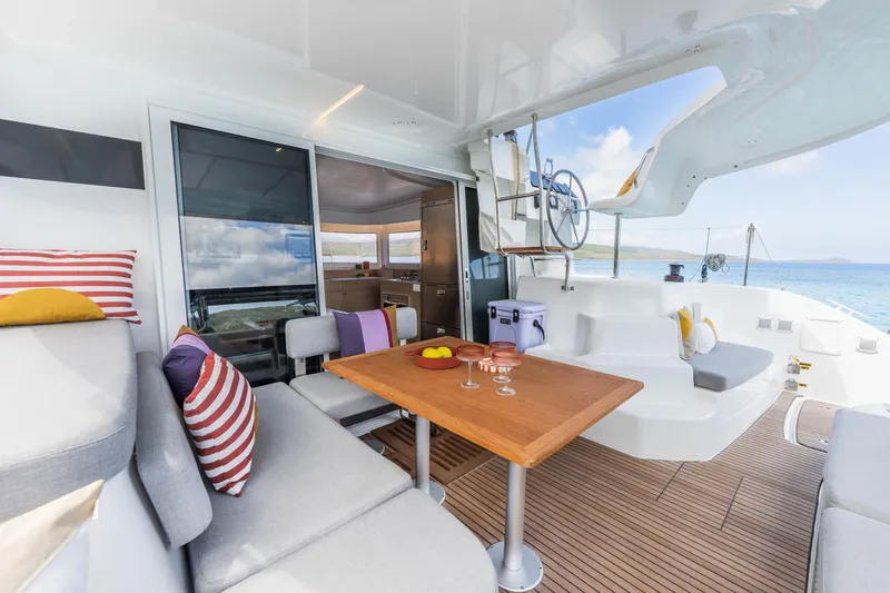 Slide: The Image of Luxurious Lagoon 38 catamaran interior, featuring modern seating, wooden table, and ocean view, 2025 model. - 18