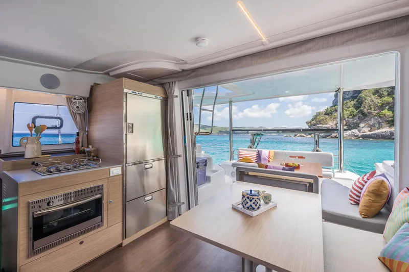 Slide: The Image of Modern Lagoon 38 catamaran interior with kitchen and dining area, overlooking serene ocean view. - 25