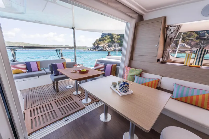 Slide: The Image of Luxurious Lagoon 38 catamaran interior with colorful cushions, overlooking serene turquoise waters, 2025 model. - 35