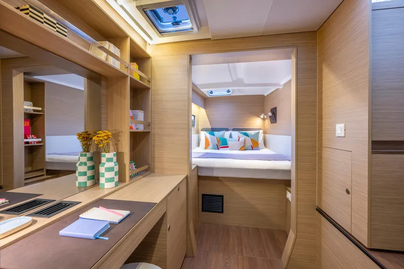 Slide: The Image of 2025 Lagoon 38 yacht interior with cozy bedroom and modern wooden decor. - 39