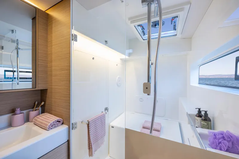 Slide: The Image of Modern bathroom in 2025 Lagoon 38 yacht with shower, sink, and window view. - 43