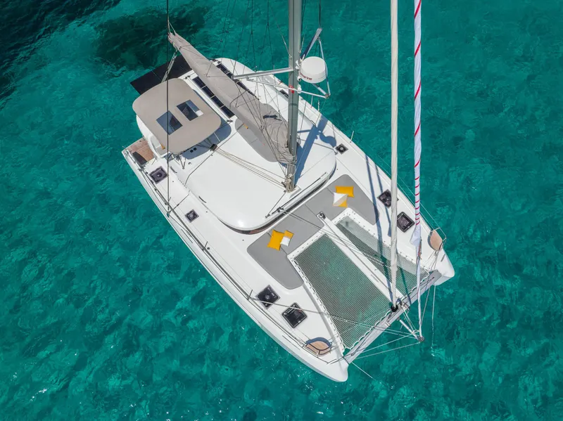 Slide: The Image of Aerial view of 2025 Lagoon 38 catamaran on clear turquoise water. - 7