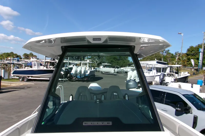 Slide: The Image of 2026 Monterey Elite 25 OB boat, front view at a marina, showcasing sleek design and windshield. - 17