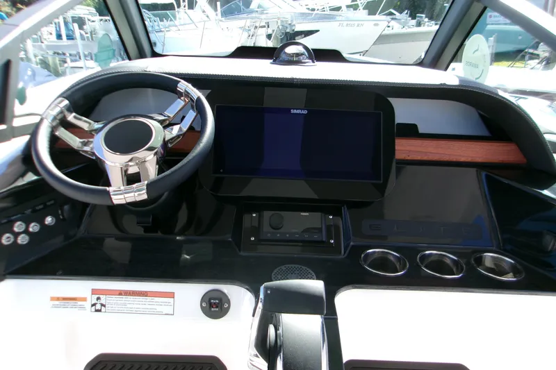 Slide: The Image of Dashboard of 2026 Monterey Elite 25 OB boat with steering wheel and Simrad display. - 9