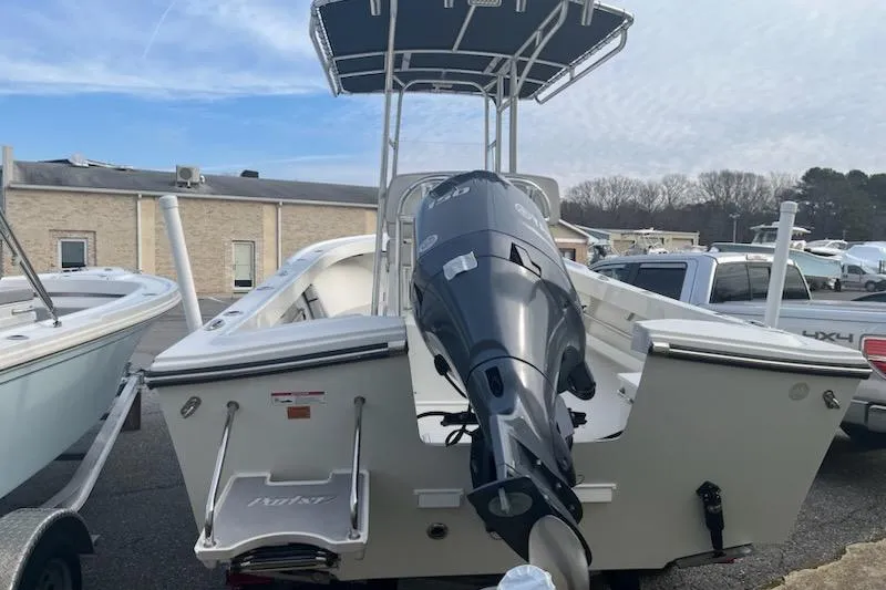 Slide: The Image of 2022 Parker 2100 Special Edition boat with outboard motor, parked outdoors. - 3