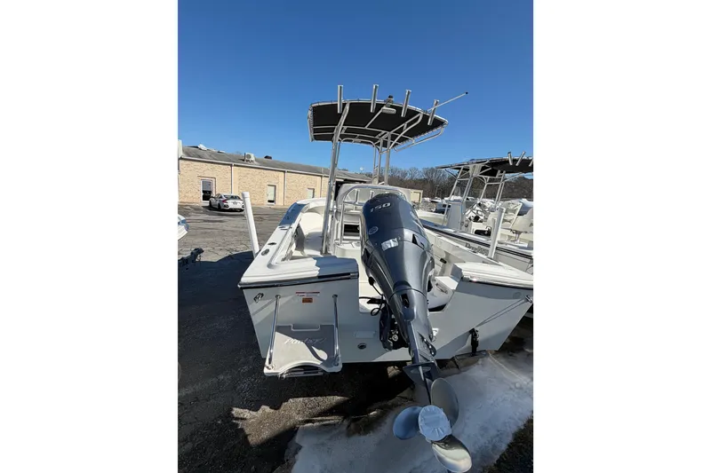 Slide: The Image of 2022 Parker 2100 Special Edition boat with outboard motor in a parking lot. - 6