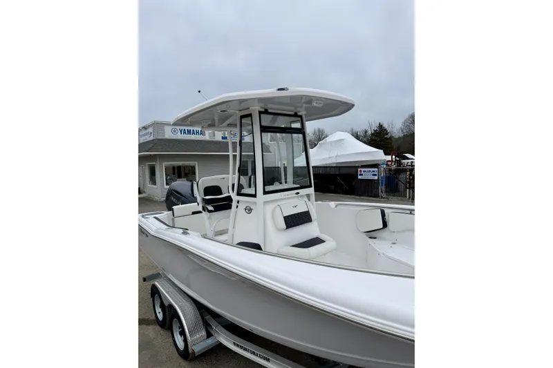 Slide: The Image of 2026 Tidewater 220 CC Adventure boat on trailer, displayed outdoors near dealership. - 11