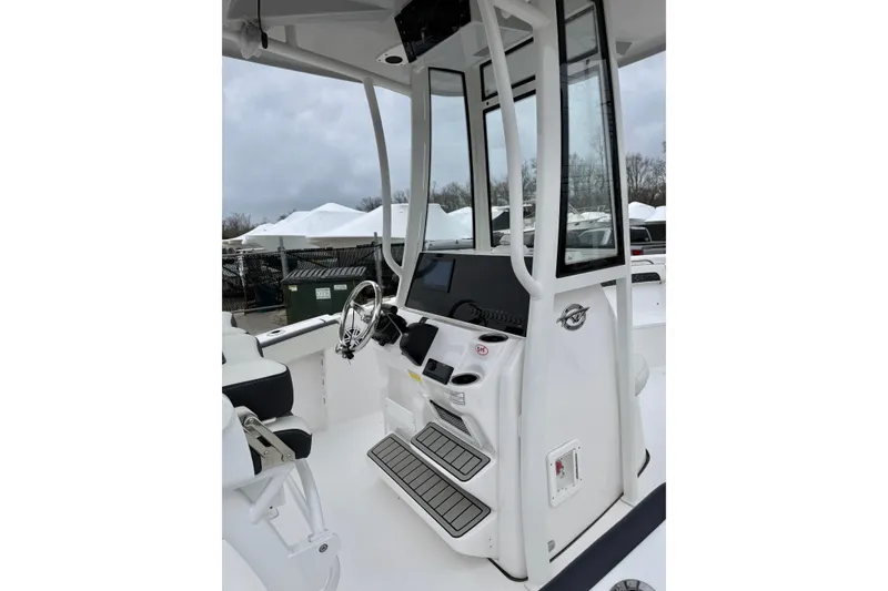 Slide: The Image of 2026 Tidewater 220 CC Adventure boat console with steering wheel and controls. - 13