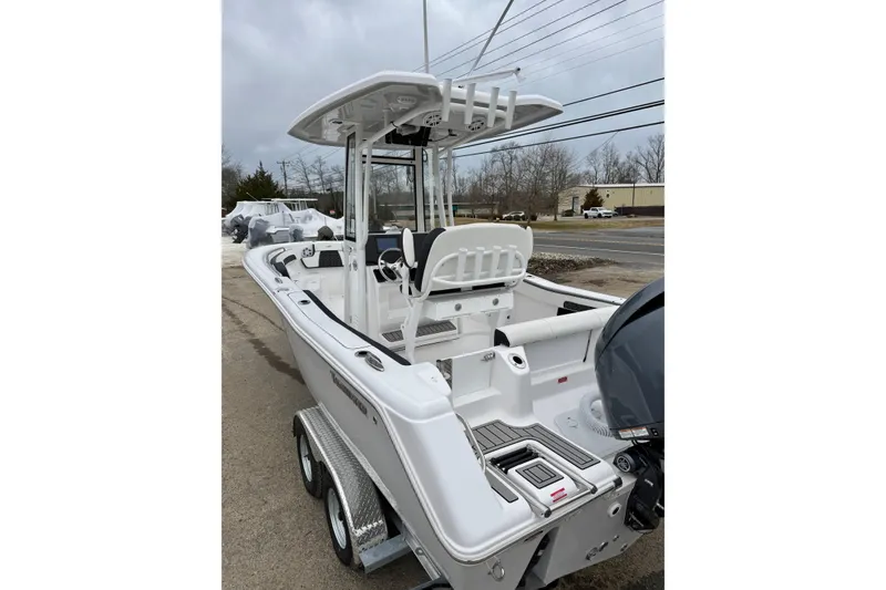 Slide: The Image of 2026 Tidewater 220 CC Adventure boat on trailer, parked outdoors on a cloudy day. - 16