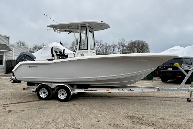 Slide: The Image of 2026 Tidewater 220 CC Adventure boat on trailer, parked outdoors. - 6