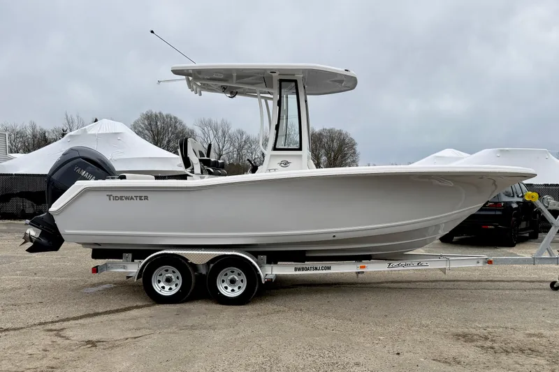 Slide: The Image of 2026 Tidewater 220 CC Adventure boat on trailer, side view, overcast sky. - 7