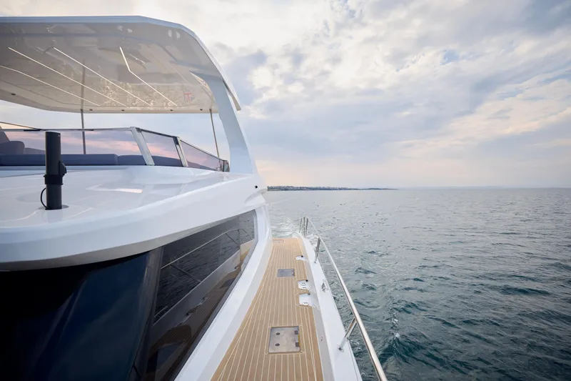 Slide: The Image of 2025 Omaya 50 Power Catamaran cruising on open sea under cloudy sky. - 16