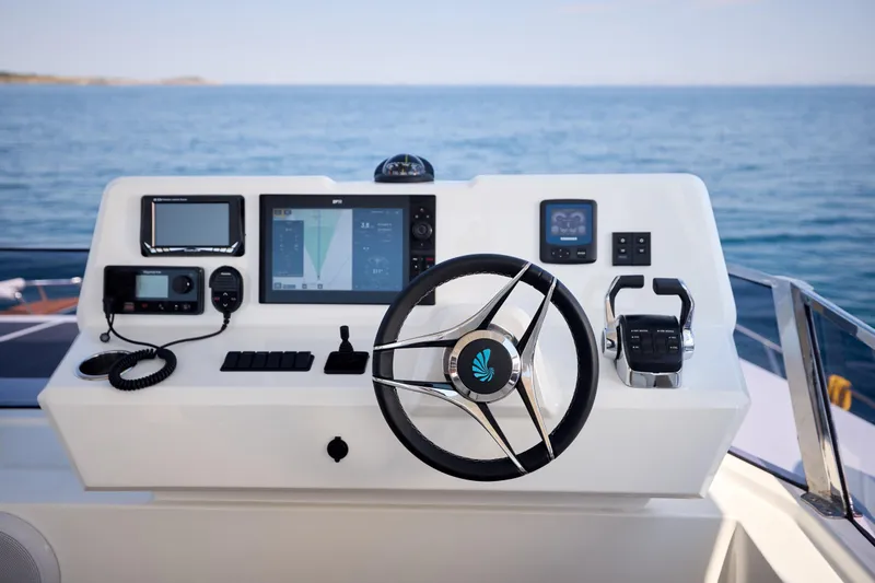 Slide: The Image of Helm of 2025 Custom Omaya 50 Power Catamaran with modern navigation equipment and steering wheel. - 48