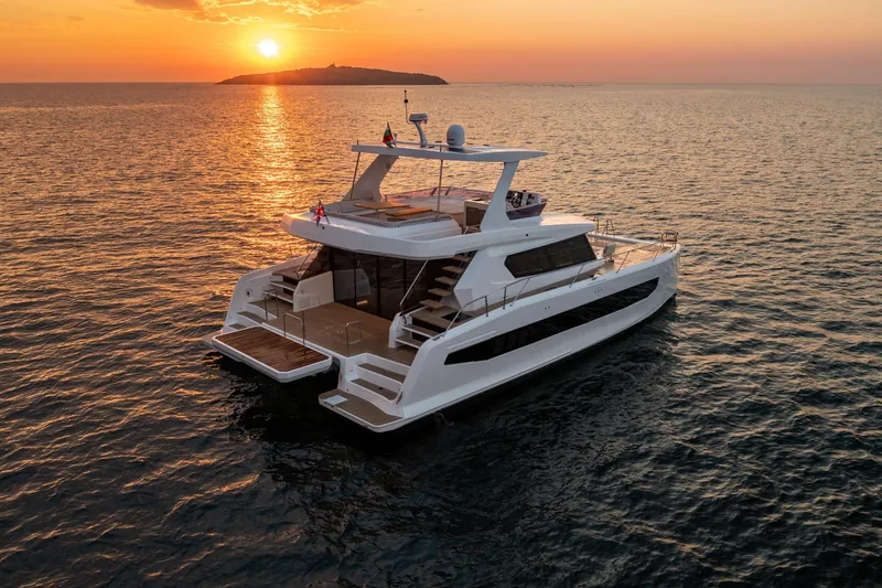 Slide: The Image of 2025 Custom Omaya 50 Power Catamaran at sunset on open sea. - 6
