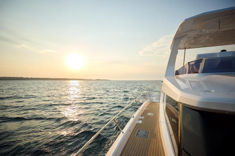 Slide: The Image of 2025 Custom Omaya 50 Power Catamaran cruising at sunset on open water. - 15