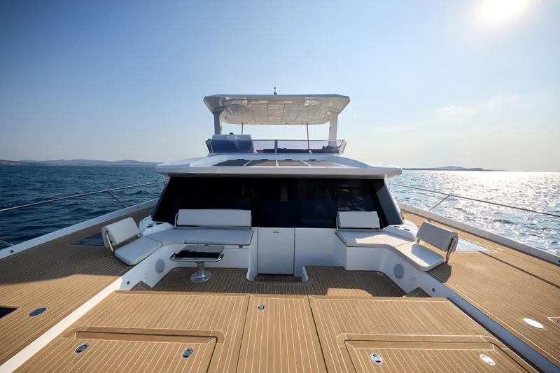 Slide: The Image of Luxurious 2025 Omaya 50 Power Catamaran on open sea, featuring spacious deck and modern design. - 18