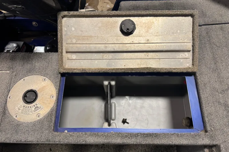 Slide: The Image of Open storage compartment in 2014 Tracker Pro Guide V-175 WT boat, featuring carpeted interior. - 15