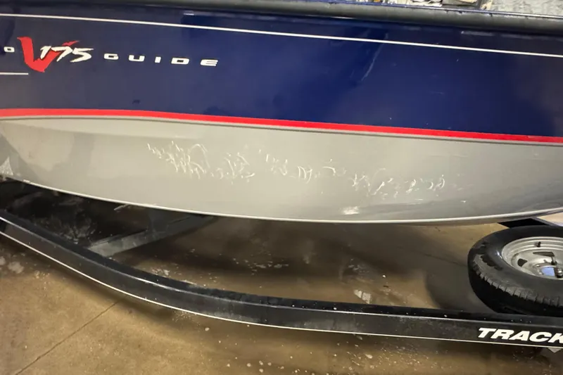 Slide: The Image of 2014 Tracker Pro Guide V-175 WT boat with visible hull scratches on trailer. - 3