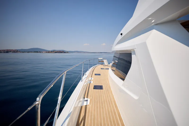 Slide: The Image of 2025 Custom Omaya 50 Power Catamaran cruising on calm waters, showcasing sleek design and spacious deck. - 14