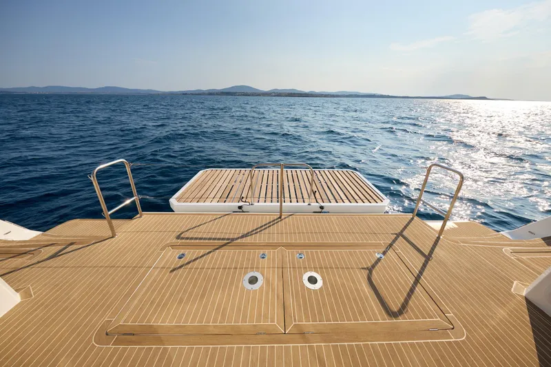 Slide: The Image of Custom Omaya 50 Power Catamaran 2025, teak deck overlooking serene ocean waters. - 31