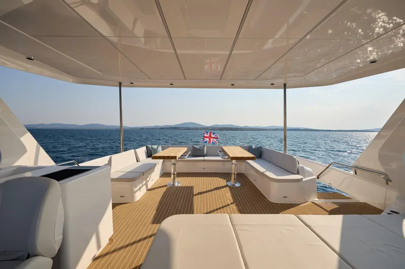 Slide: The Image of Luxurious 2025 Omaya 50 Power Catamaran deck with seating, ocean view, and British flag. - 45
