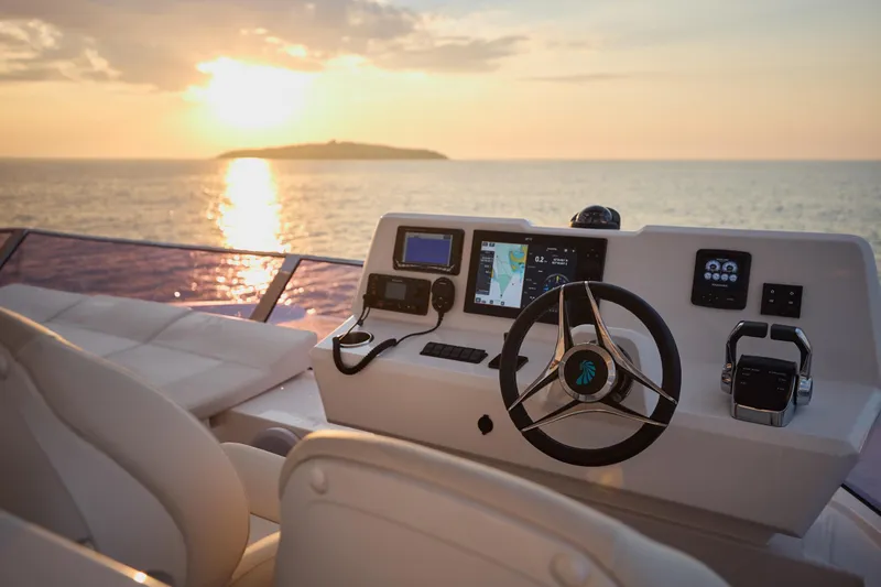 Slide: The Image of Helm of 2025 Omaya 50 Power Catamaran at sunset, featuring modern navigation equipment. - 49