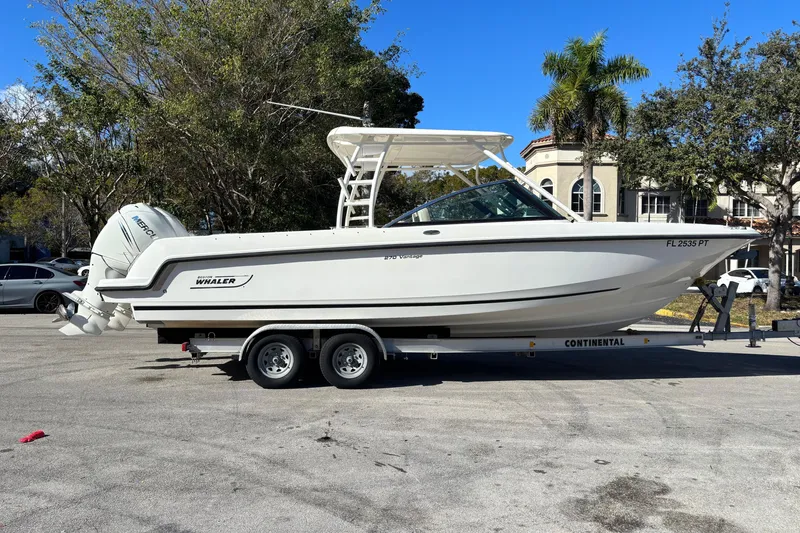 The Image of 2014 Boston Whaler 270 Vantage boat on trailer, parked outdoors with trees and buildings in background. - 0