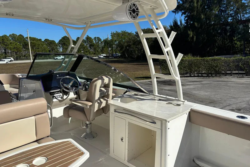 Slide: The Image of 2014 Boston Whaler 270 Vantage boat interior with helm, seating, and storage. - 13