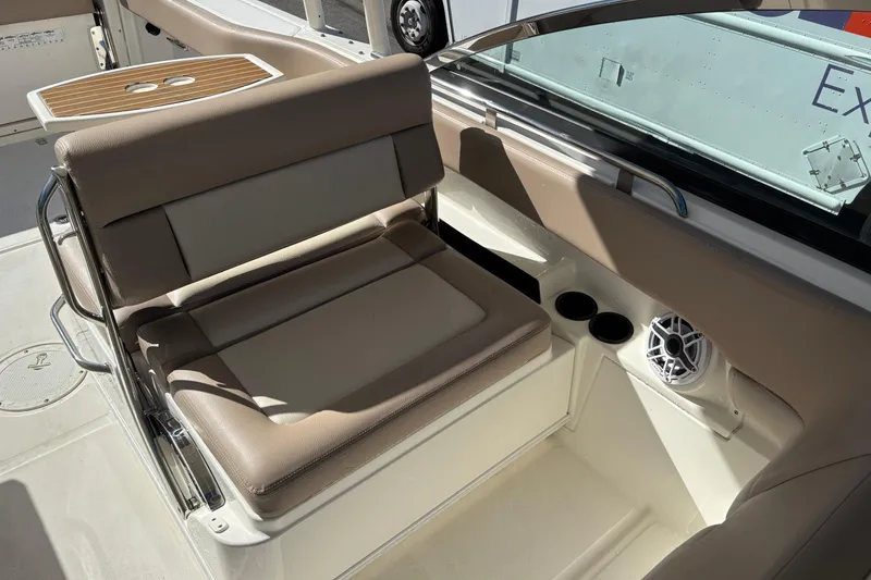 Slide: The Image of 2014 Boston Whaler 270 Vantage interior with beige seating and cup holders. - 17
