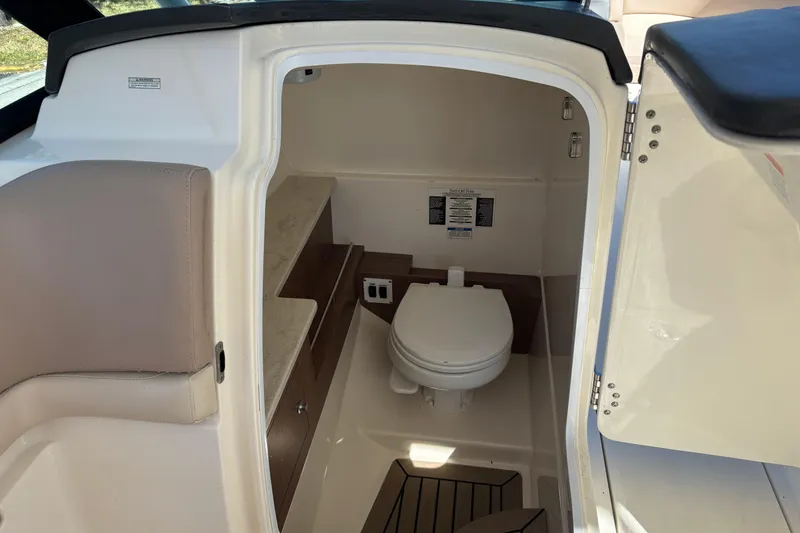 Slide: The Image of Interior of 2014 Boston Whaler 270 Vantage boat, featuring a compact marine toilet. - 19