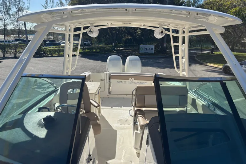 Slide: The Image of 2014 Boston Whaler 270 Vantage boat interior with seating and helm, parked outdoors. - 24