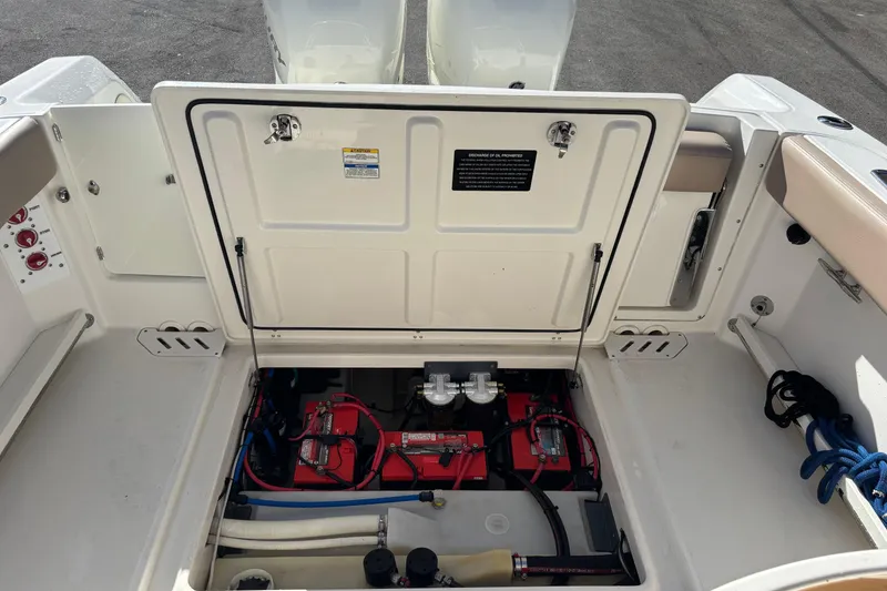 Slide: The Image of Open battery compartment of 2014 Boston Whaler 270 Vantage boat, showing red batteries and wiring. - 26