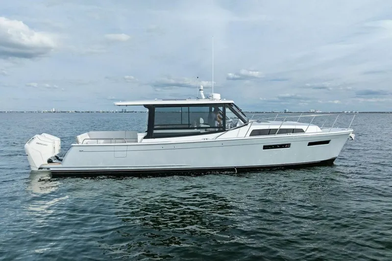 Slide: The Image of 2025 MJM 42 boat on calm water, featuring sleek design and modern outboard engines. - 33