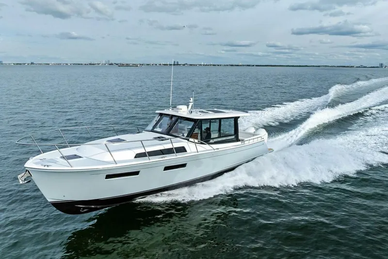 Slide: The Image of 2025 MJM 42 yacht cruising on open water under cloudy skies. - 42