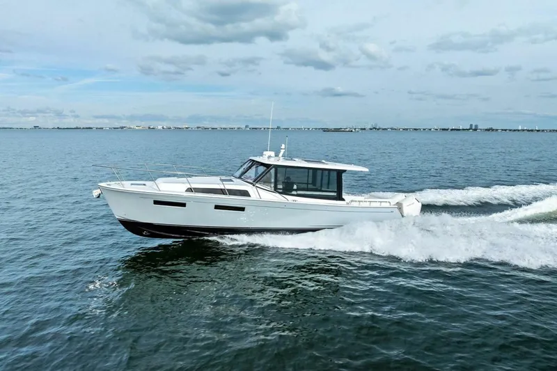 Slide: The Image of 2025 MJM 42 boat cruising on open water under a cloudy sky. - 43