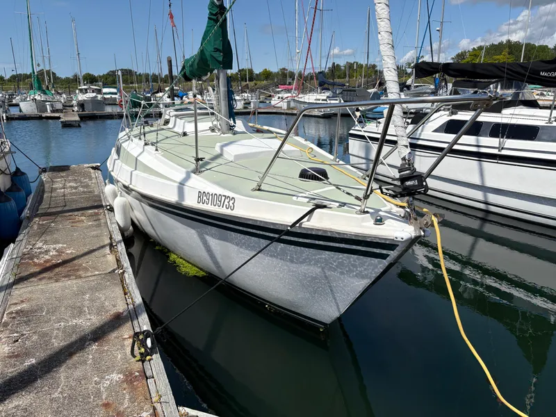 Slide: The Image of 1981 Newport 27 S sailboat docked in marina, surrounded by other boats. - 1