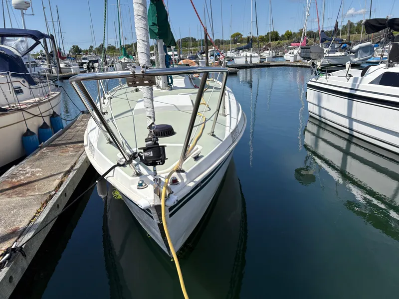 Slide: The Image of Sailboat Newport 27 S, 1981 model, docked in a marina with calm waters. - 2