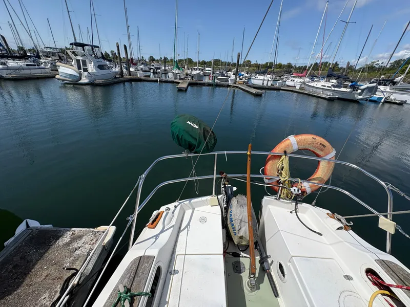 Slide: The Image of 1981 Newport 27 S sailboat docked in a marina, surrounded by other boats. - 22