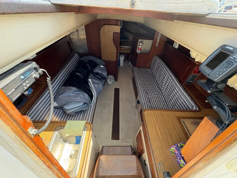 Slide: The Image of Interior of 1981 Newport 27 S sailboat with striped seating and navigation equipment. - 24