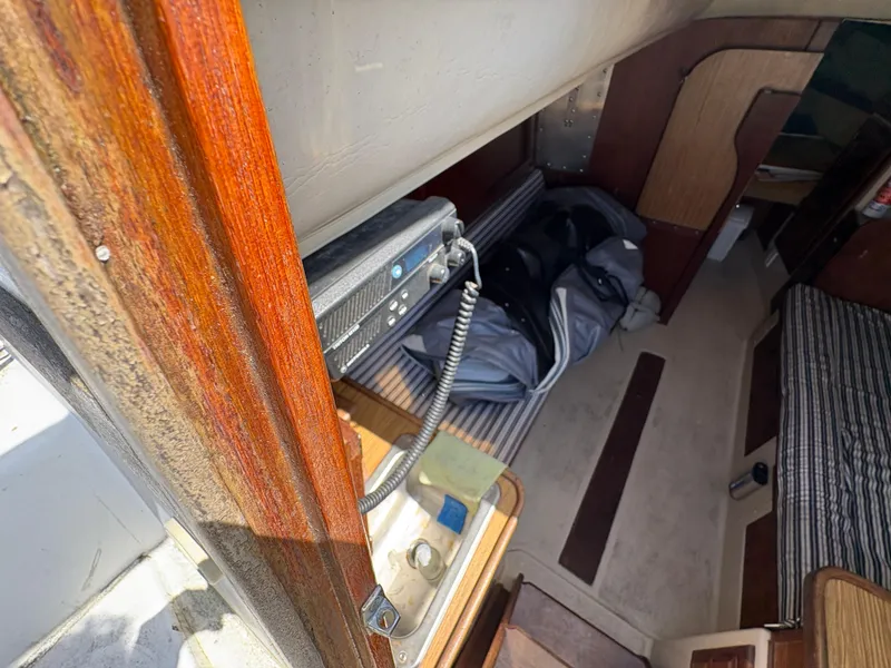Slide: The Image of Interior of a 1981 Newport 27 S sailboat, featuring wood paneling and a compact cabin space. - 26
