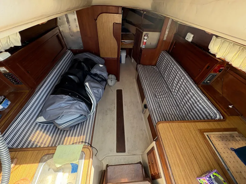 Slide: The Image of Interior of a 1981 Newport 27 S sailboat with striped seating and wooden cabinetry. - 28