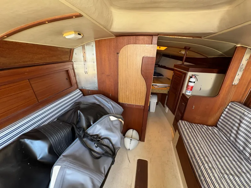 Slide: The Image of Interior of 1981 Newport 27 S sailboat with striped seating and wooden paneling. - 29